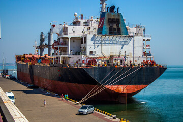 A large ship stands stern moored in the port