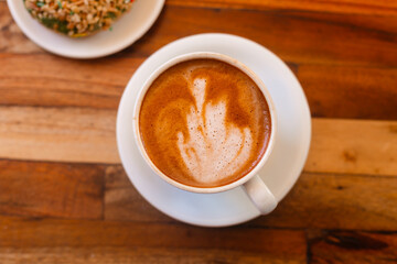 Delicious cappuccino with beautiful foam view from above. Aromatic coffee with dessert