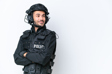 Young caucasian SWAT man isolated on white background with arms crossed and happy