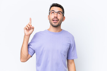 Fototapeta premium Young caucasian man isolated on white background pointing up and surprised