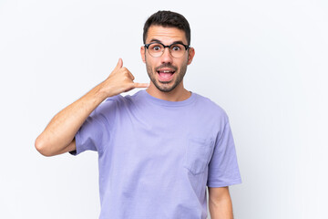 Young caucasian man isolated on white background making phone gesture. Call me back sign