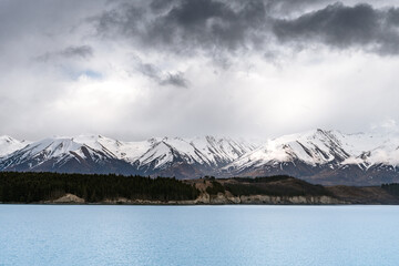 A scenic landscape of Aoraki Mount Cook background - Lake Pukaki with blue sky and clouds, South Island, New Zealand. View from Mt Cook Alpine Salmon Shop.