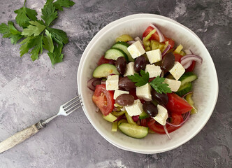 Vegetarian Greek salad with feta cheese, olives, tomatoes, cucumber, peppers, red onions, herbs,...