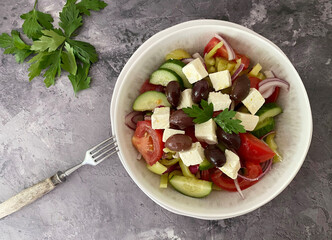 Vegetarian Greek salad with feta cheese, olives, tomatoes, cucumber, peppers, red onions, herbs, marinated with olive oil and lemon juice.