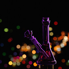 purple laboratory bong for smoking marijuana against the dark background of the night city. glass...