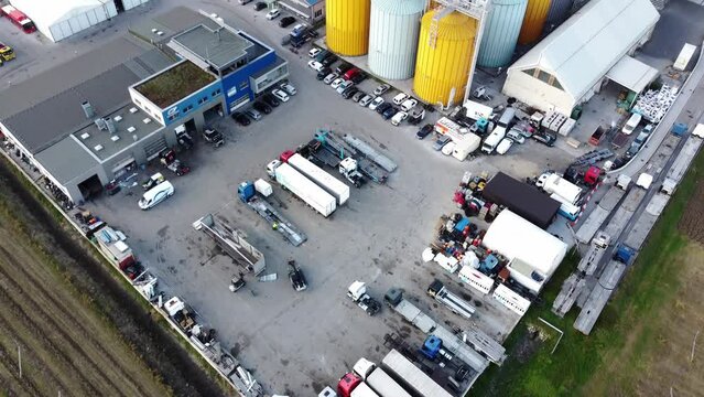 Factory lot, industrial zone with some trucks and outdoor warehouse, drone shot