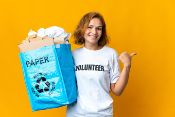 Young Georgian girl holding a recycling bag full of paper to recycle pointing to the side to present a product