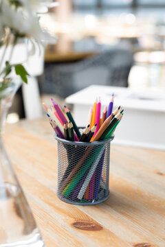 Colorful crayons in metal mug. Colored pencils. Hobby, drawing concept, selective focus, close-up. 