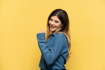 Young Russian girl isolated on yellow background celebrating a victory