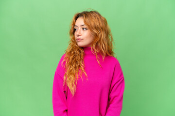 Young caucasian woman isolated on green screen chroma key background looking to the side