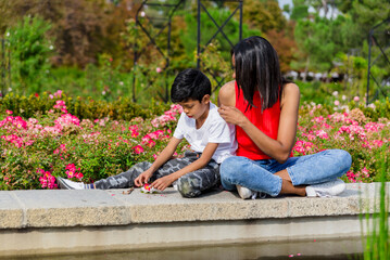 Fototapeta na wymiar Mother and son having fun together while enjoying a day in the park.