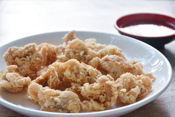 crispy fried Korean chicken with bread crumb and egg yolk on plate dipping barbecue sauce