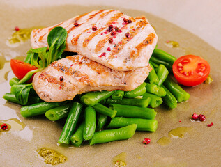 Grilled chicken fillets on green beans
