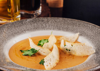 Pea cream soup in plate with bread chips