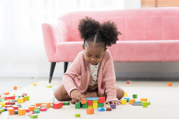 Little child girl playing a lot of toy on floor at home. Happy African American girl kid playing toys at school