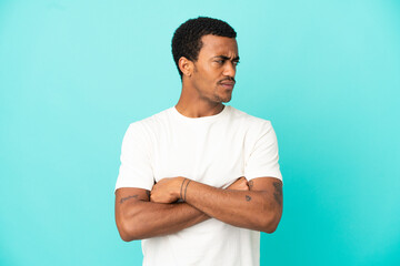 Fototapeta premium African American handsome man on isolated blue background keeping the arms crossed