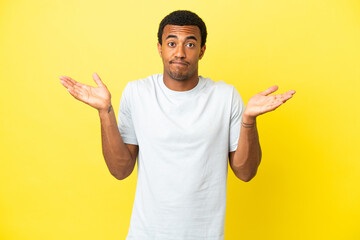African American handsome man on isolated yellow background having doubts while raising hands