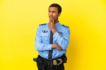 African American police man over isolated yellow background having doubts and thinking