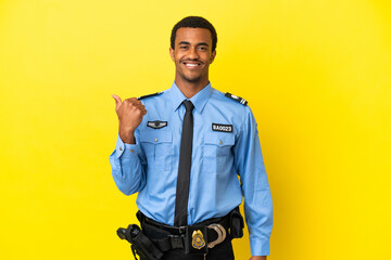 African American police man over isolated yellow background pointing to the side to present a product