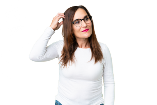 Middle age woman over isolated chroma key background having doubts while scratching head