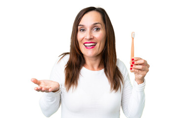 Middle age woman brushing teeth over isolated chroma key background with shocked facial expression