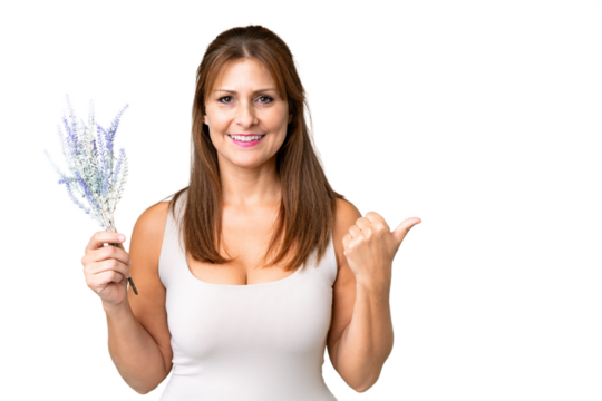Middle age caucasian woman holding lavender over isolated background pointing to the side to present a product