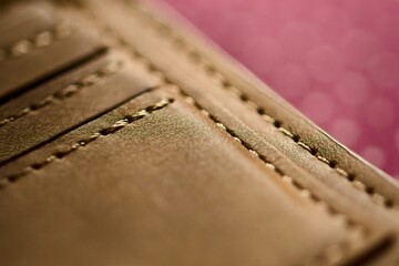 Handmade tan leather wallet, detail of the stitching. Close up, macro shot.