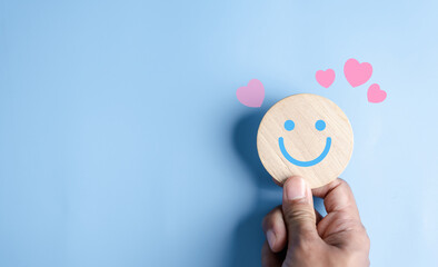 Hands holding blue happy smile face. mental health positive thinking and growth mindset, mental health care recovery to happiness emotion. - obrazy, fototapety, plakaty