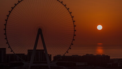 Sunset over Bluewaters island with modern architecture and ferris wheel aerial timelapse.