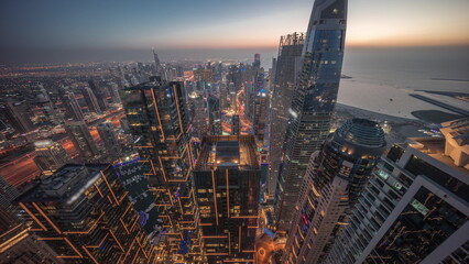 Obraz premium Skyline sunset view of Dubai Marina showing canal surrounded by skyscrapers along shoreline day to night timelapse. DUBAI, UAE