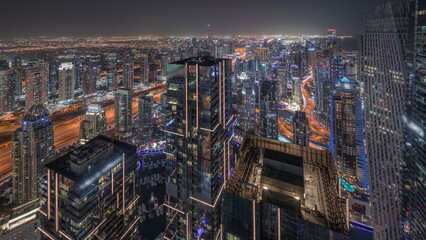 Dubai Marina and JLT district with traffic on highway between skyscrapers aerial day to night timelapse.