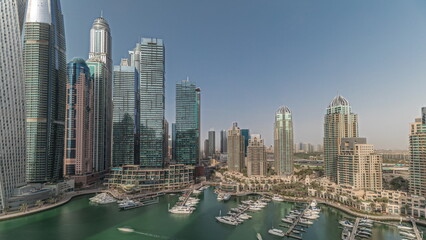 Obraz premium Panorama showing Dubai marina tallest skyscrapers and yachts in harbor aerial timelapse.