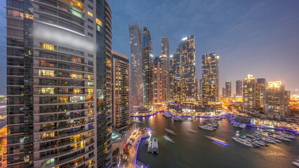 Obraz premium Dubai marina tallest skyscrapers and yachts in harbor aerial day to night timelapse.