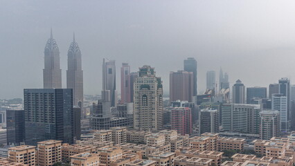 Fototapeta premium Skyscrapers in Barsha Heights district and low rise buildings in Greens district aerial night to day timelapse.