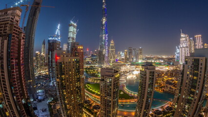 Dubai Downtown cityscape with tallest skyscrapers around aerial day to night timelapse.