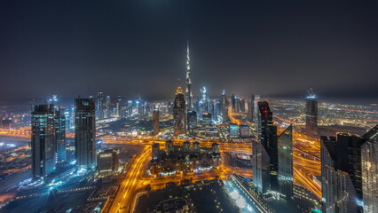 Aerial panorama of tallest towers in Dubai Downtown skyline and highway all night timelapse.
