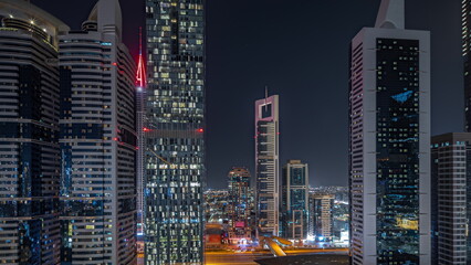 Fototapeta na wymiar Panorama showing aerial view of Dubai International Financial District with many skyscrapers night timelapse.