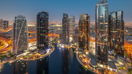 Fototapeta na wymiar Tall residential buildings at JLT aerial day to night timelapse, part of the Dubai multi commodities centre mixed-use district.