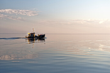 Fishing boat on sunset background - 611419642