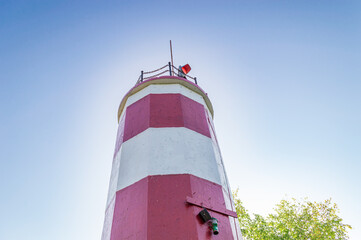 White-Red Lighthouse on the Background a Cloudless Blue Sky