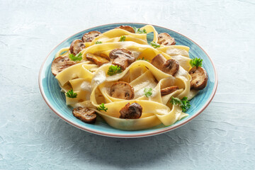 Mushroom pasta with creamy sauce and parsley, on a stone background