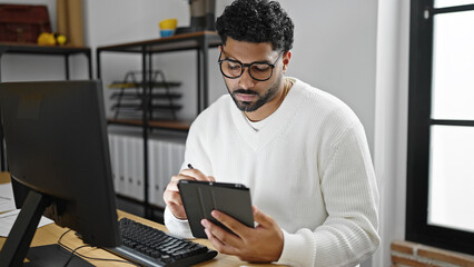 African american man business worker using computer writing on touchpad working at office