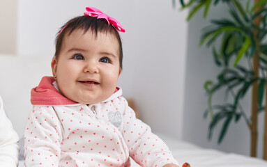 Adorable hispanic baby smiling confident sitting on bed at bedroom