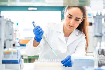 Scientist with dropper dripping liquid into a test tube in scientific laboratory, concept of pharmaceutical environment