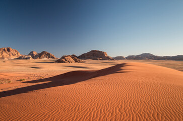 Fototapeta na wymiar sand dunes and mountans in the desert before sunset, Wadi Rum, Jordan