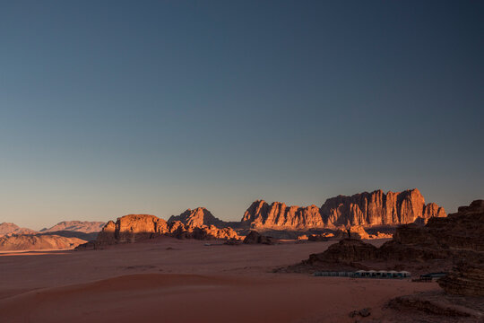 sunrise over the desert camp with Jebel Qatar sandstone cliffs in the background, Wadi Rum, Jordan © Hodossy