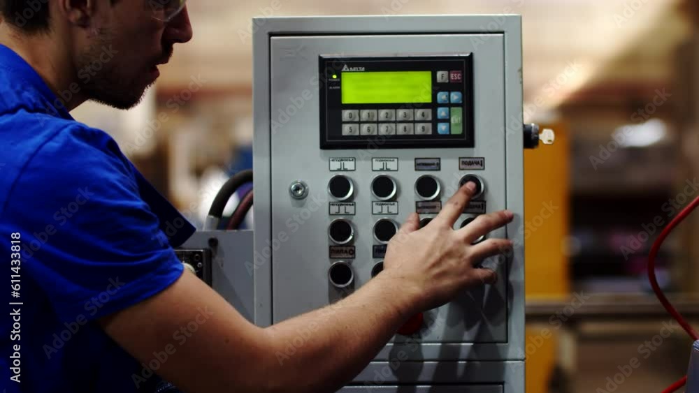 Poster professional worker watching over manufacturing process on an indoor production area and push the bu