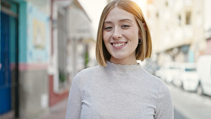 Young blonde woman smiling confident standing at street