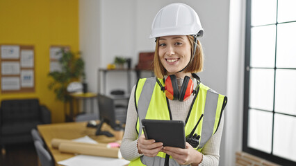 Young blonde woman architect smiling confident using touchpad at office