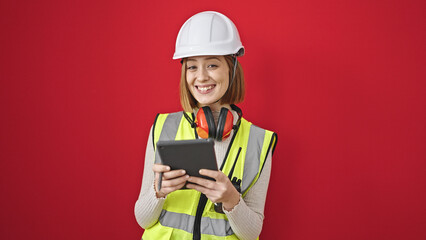 Young blonde woman architect smiling confident using touchpad over isolated red background